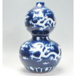 An early 20th Century blue and white Chinese double gourd vase having a blue ground with white