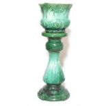 An early 20th century green majolica planter and stand in the Art Nouveau manner having flower and