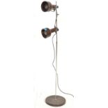 A retro 20th Century twin adjustable spot floor standing lamp raised on a circular base in