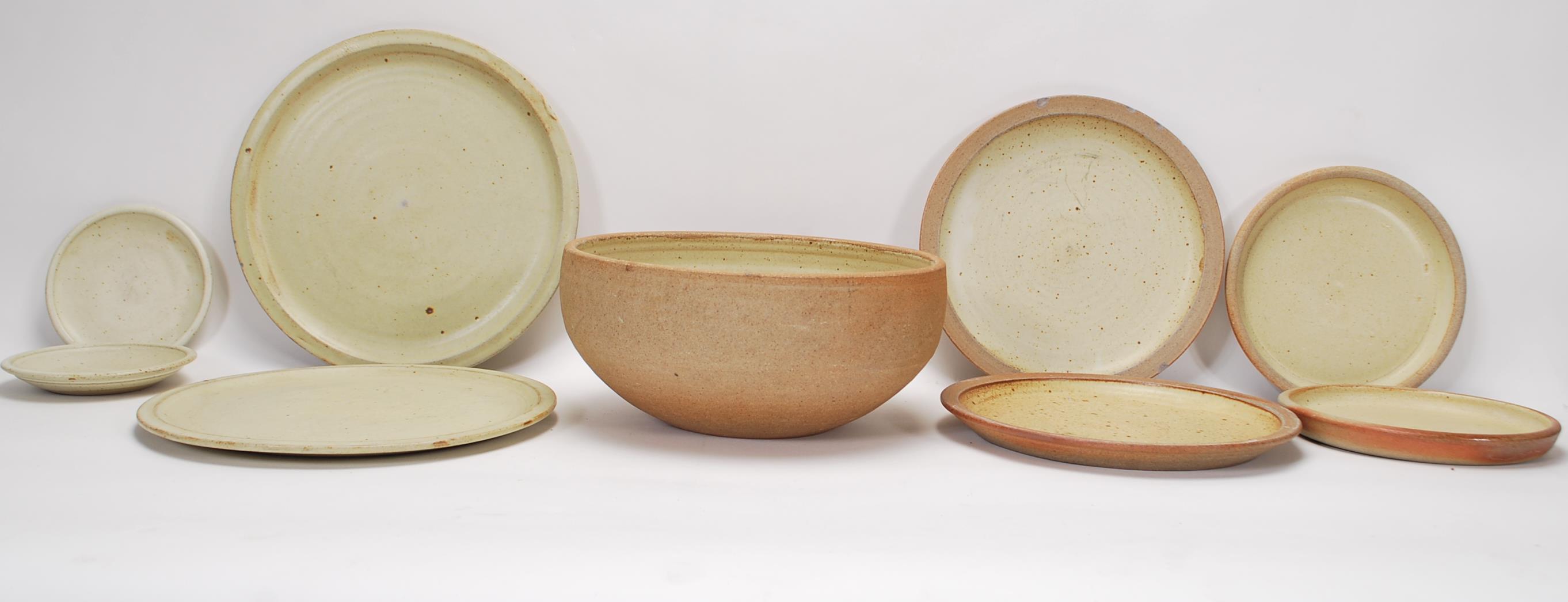 A collection of mid century Ray Finch studio pottery items being ochre fired to include fruit