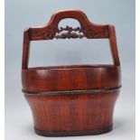 A contemporary Chinese water pale / bucket of tapering form having a carved carrying handle atop and