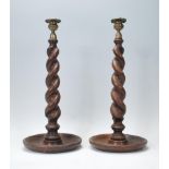 A pair of early 20th Century carved oak barley twist candlesticks of large form having brass sconces