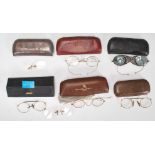 A selection of early 20th Century glasses / spectacles in their original cases including some with
