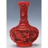 A Chinese 20th Century red cinnabar vase having a waisted neck and squat globular body decorated