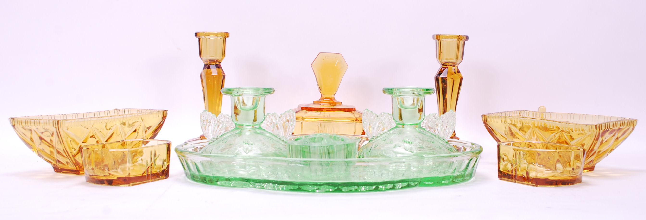 Two early 20th Century Art Deco pressed glass dressing table sets to include a part green glass