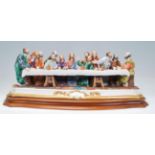 A 20th century Italian Capodimonte Ester Last Supper figurine group depicted on a wooden base with