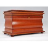 A mahogany tea caddy of sarcophagus form, hinged lid opening to reveal two lidded compartments and