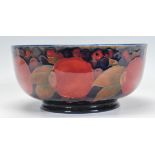 WILLIAM MOORCROFT: A "POMEGRANATE" FOOTED BOWL, circular form, painted in polychrome with a frieze