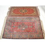 A Persian / Islamic 20th century flor rug with red ground and central medallions having decorative