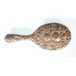 A silver hallmarked vanity dressing table hand mirror, the mirror in relief of rococo form,