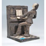 A contemporary plaster amateur sculpture diorama of a pianist at piano being played on a