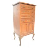 An Edwardian mahogany inlaid pedestal music cabinet. Raised on cabriole legs with pad feet having