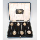 A set of six cased silver hallmarked tea spoons with black coffee bean finials, set within a blue