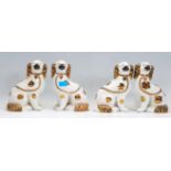 A group of four early 20th Century Staffordshire fire side dogs having gilt details. Measures 24cm
