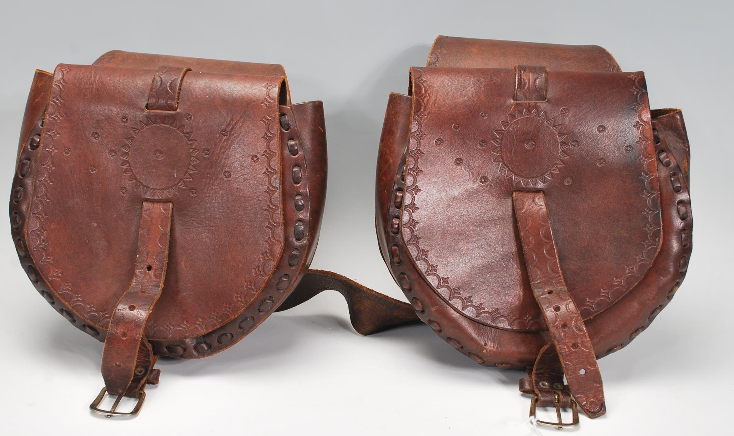 A pair of vintage 20th Century brown leather stitched saddle bags with rounded compartments having