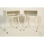 A pair of retro vintage 20th century white painted bedside table cabinets raised on tall cylindrical