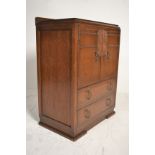 An early 20th Century Art Deco oak tallboy - linen cupboard raised on a plinth base with cupboard