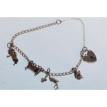A small silver charm bracelet having a total of four charms with a silver heart lock. The charms