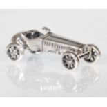 A stamped 925 silver figurine in the form of a classic soft top car with articulated wheels.