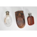 Two early 20th Century antique pocket flasks to include a glas bottle of ovular form with a white