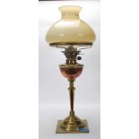 An 20th Century antique brass oil lamp having a square base with knopped column, copper reservoir