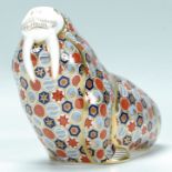 A Royal Crown Derby porcelain paperweight figurine of a walrus being stamped to the underside and