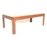 A 20th Century teak wood coffee table, rectangular top over fitted frieze raised on shaped supports.
