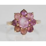 A 9ct yellow gold ring having a flower head mount set with round faceted cut amethyst. Marks rubbed.