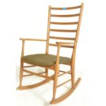 A retro 20th Century Scandinavian inspired teak wood rocking chair, railback splat with open arms