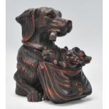 A carved black forest wooden inkwell in the form of a dog with a satchell filled with fox cubs.