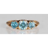 A hallmarked 9ct gold and blue zircon three stone ring. The ring set with three graduating round