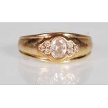 A hallmarked 9ct gold and CZ band ring. The ring having a bezel set oval cut CZ  flanked by trefoils