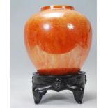 A Carlton Armand lustre vase of bulbous tapering form having a sponge effect orange ground with gilt