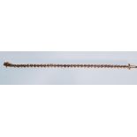 A ladies gold tennis bracelet set with 38 round cut diamonds having a tongue in groove clasp. Weight