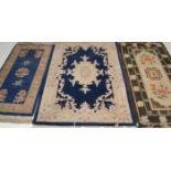A collection of Chinese floor rugs to include blue and white example, blue and floral medallion