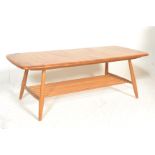 A retro 20th Century Ercol Golden Dawn Windsor pattern beech and elm coffee table raised on tapering