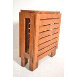 A small folding / gate leg teak wood garden table opening in to rectangular form. Measures 73cm high