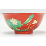 A 20th Century Chinese footed bowl having an ocher ground with enamelled lotus leaf and flower