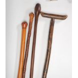 A group of four 20th Century walking sticks to include a malacca stick with knop to the top, a