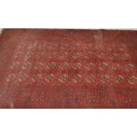A large vintage early 20th Century Persian style floor rug on red group with large central geometric