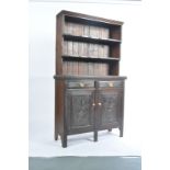An Edwardian oak and mahogany dresser having twin cupboard and short drawer base with upright