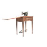 A mid century mahogany Singer Sewing Machine work table. Raised on turned legs with fold over top