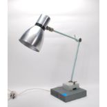 A vintage retro 20th Century industrial work desk lamp raised on a wooden plinth base attached by
