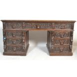 A late 19th century Victorian Jacobean revival heavily  carved oak twin pedestal desk, configuration