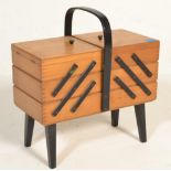 A retro 20th Century beech cantilever metamorphic work / sewing box, carry handle over sectional