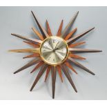 A retro 20th Century teak wood and brass sunburst / atomic wall clock, the silvered clock face