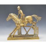 A 20th Century brass statue depicting a horse with rider leaping over a fence, all being fixed to