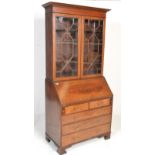 An Edwardian mahogany inlaid bureau bookcase raised on bracket feet with chest under bureau. Above