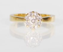 A stamped 18ct gold ring set with a cluster of dia