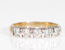 A 9ct gold five stone moissanite ring set on a yel